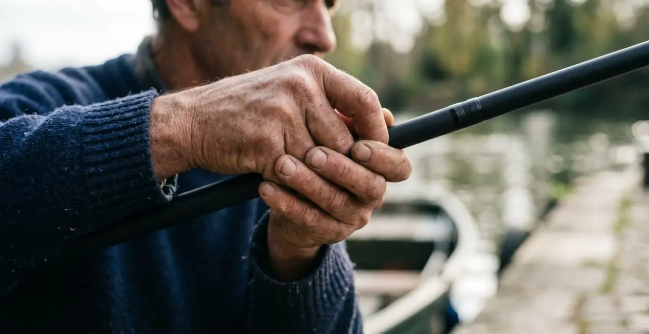 Main de pêcheur tenant une canne à pêche, focus sur le contact tactile et les sensations